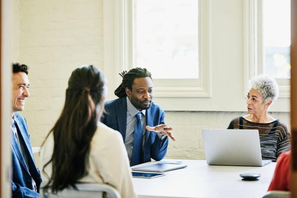 A consultant speaks to a group of professionals around a table.